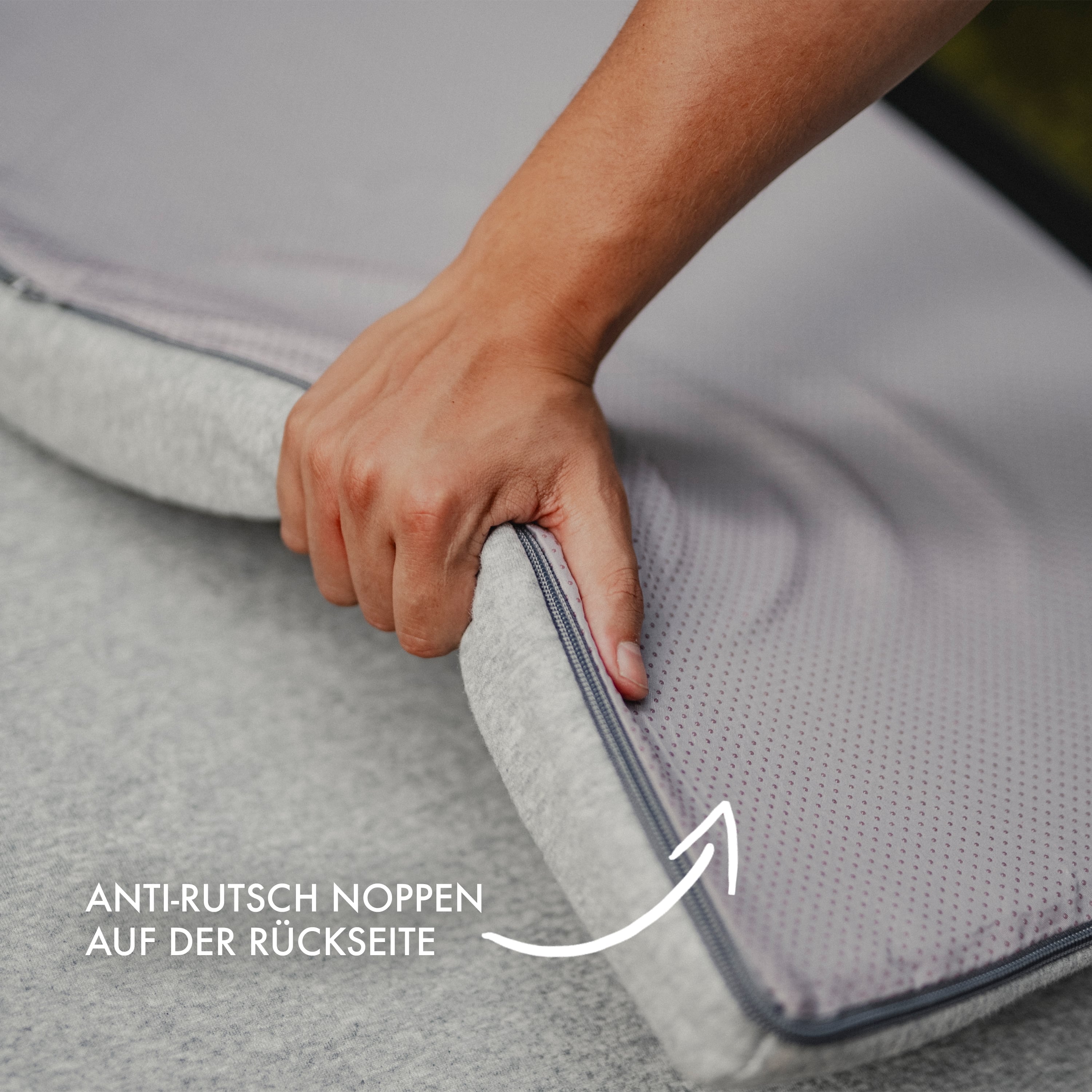 Detailaufnahme des grauen Matratzentoppers zur Veranschaulichung der Anti-Rutsch Noppen auf der Rückseite.